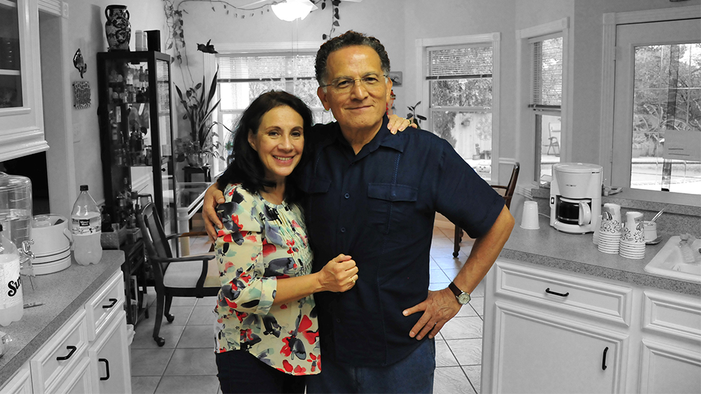 Yolanda and Edgar Sanchez-Sinencio embrace in their kitchen.