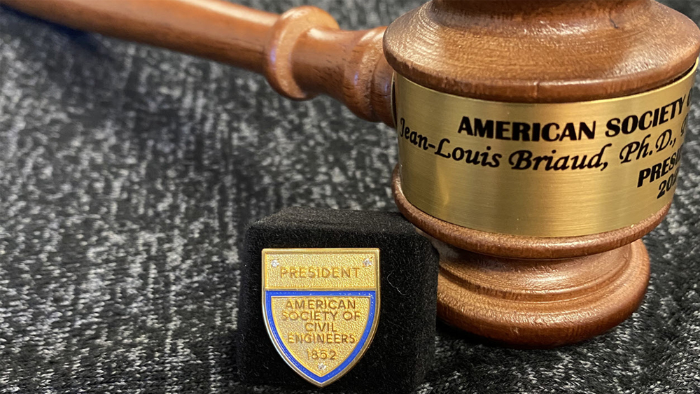 A gavel with Jean-Louis Briaud's name on it, next to a metal desk sign indicating that he is president of the American Society of Civil Engineers.