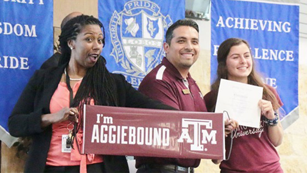 Ally Moore standing with a Texas A&M recruiter and her high school principal.