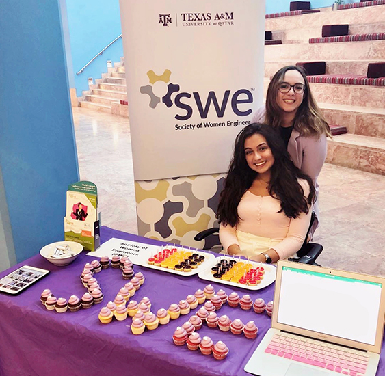 Sara Amani at a Society of Women Engineers table at an event 