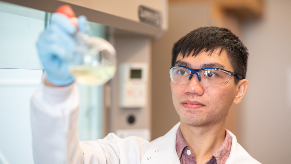 Student holding beaker of liquid in lab