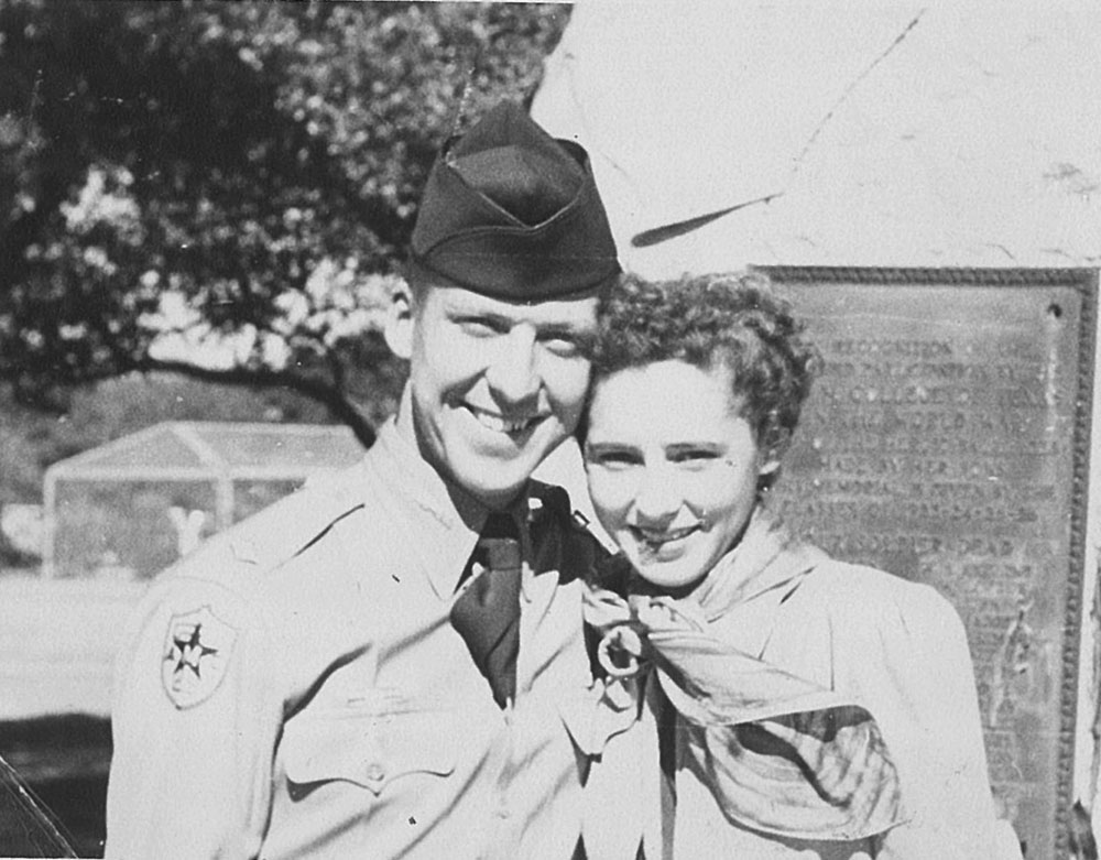 Black and white photo of male Corps of Cadet student smiling with girlfriend outside.