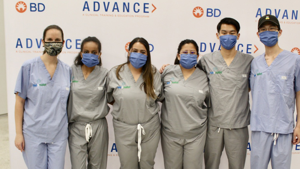 Students in masks stand next to their sponsor from BD