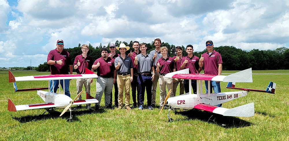 Texas A&amp;M University SAE Aero Design team and advisors posed outside by their red, white and blue Texas flag-themed biplane remote-controlled aircrafts.
