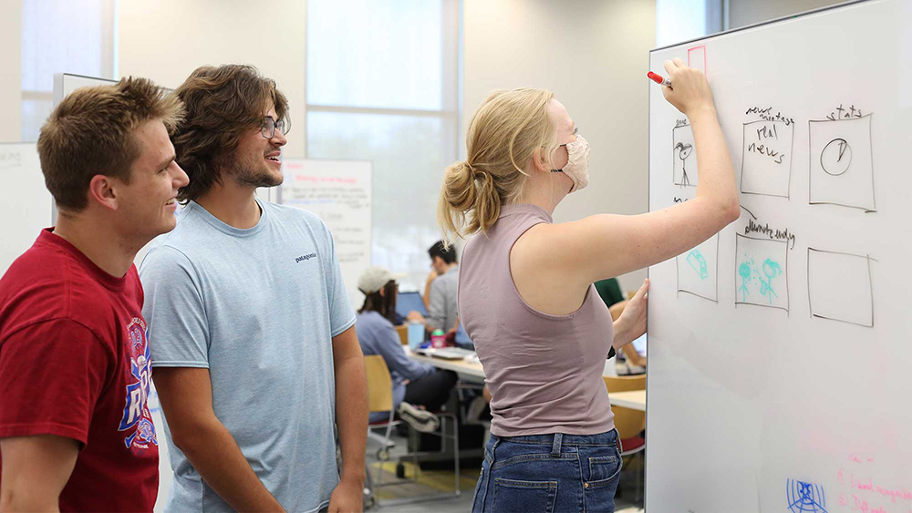 Students brainstorm ideas for their prototype at Aggies Invent using a white board.