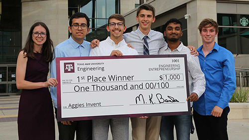 Green Thumb, the first-place team from Aggies Invent, is holding a giant check for $1000. 
