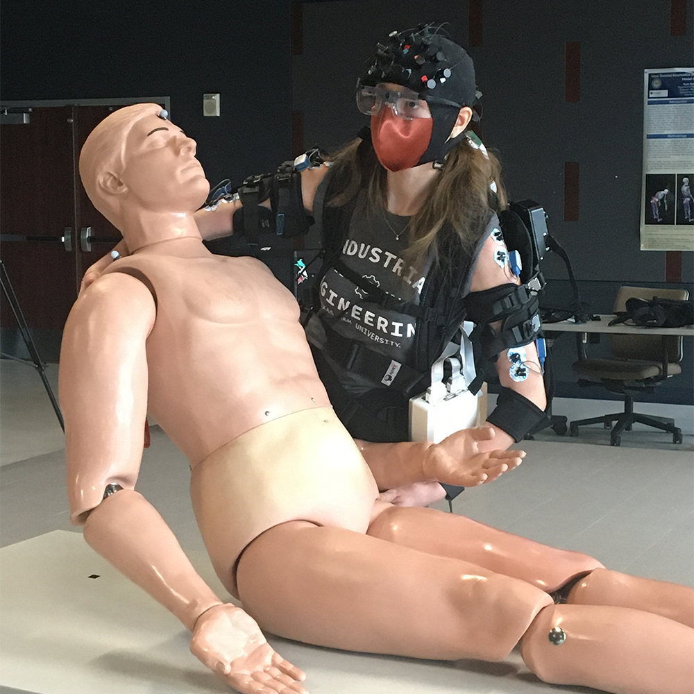 Doctoral student Sarah Hopko wearing an exoskeleton while performing patient handling tasks. 