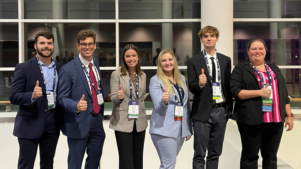 Ocean engineering students giving a thumbs up at the 2021 Society of Naval Architects and Marine Engineers Maritime Convention