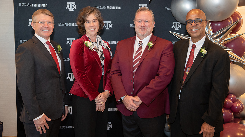 From left, Bill Crane, Holly E. Ridings, John “Lindsley” Ruth and Kenneth Washington stand in front of Texas A&amp;M backdrop and balloon display