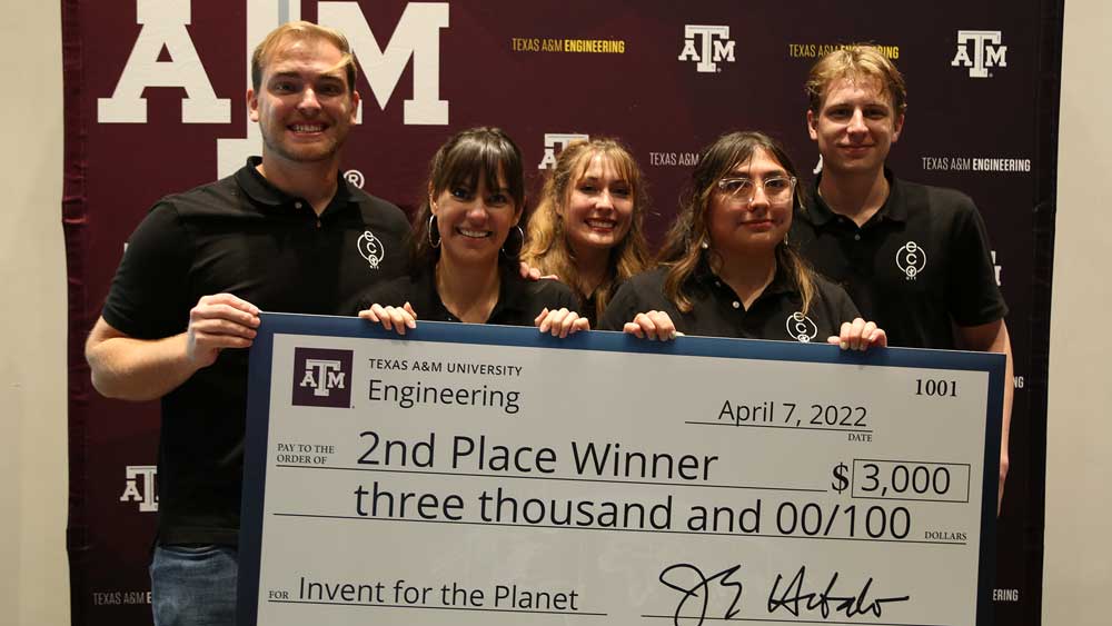 Group of students holding up a big check for 2nd place.
