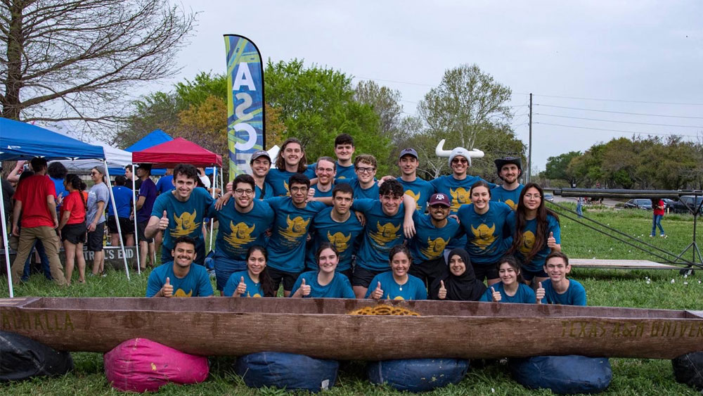 A group of people standing in front of a canoe