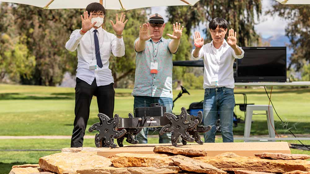 From left: Yuan Wei (graduate student), Tye Brady (Amazon Robotics) and Kangneoung Lee (graduate student) interact with α-WaLTR during a live demonstration.