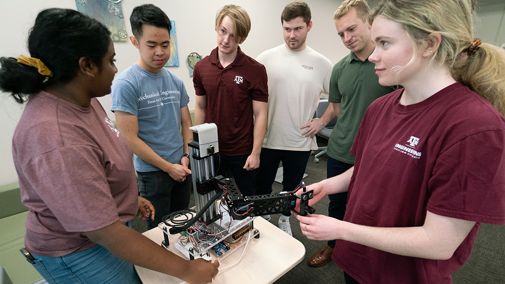 A team of mechanical engineering students demonstrating their capstone project.