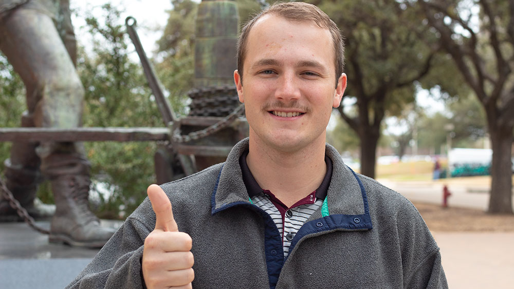 Male student Blake Ropers smiling while standing outdoors on Texas A&amp;M University campus