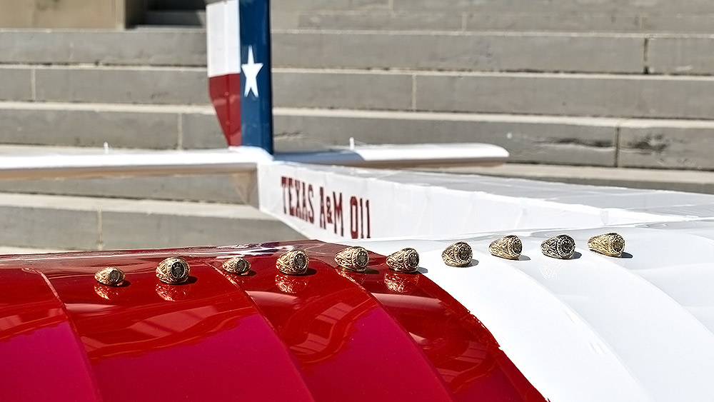 Aggie rings in a line on the wing of a student-designed aircraft painted like the Texas flag.