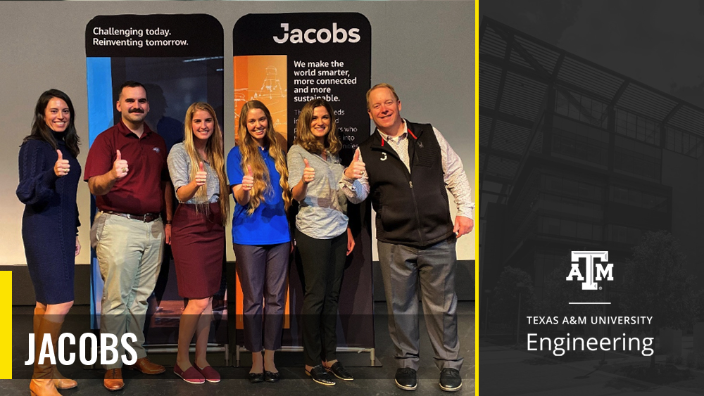 Six Jacobs employees stand together doing the gig 'em sign, showing their Aggie rings.