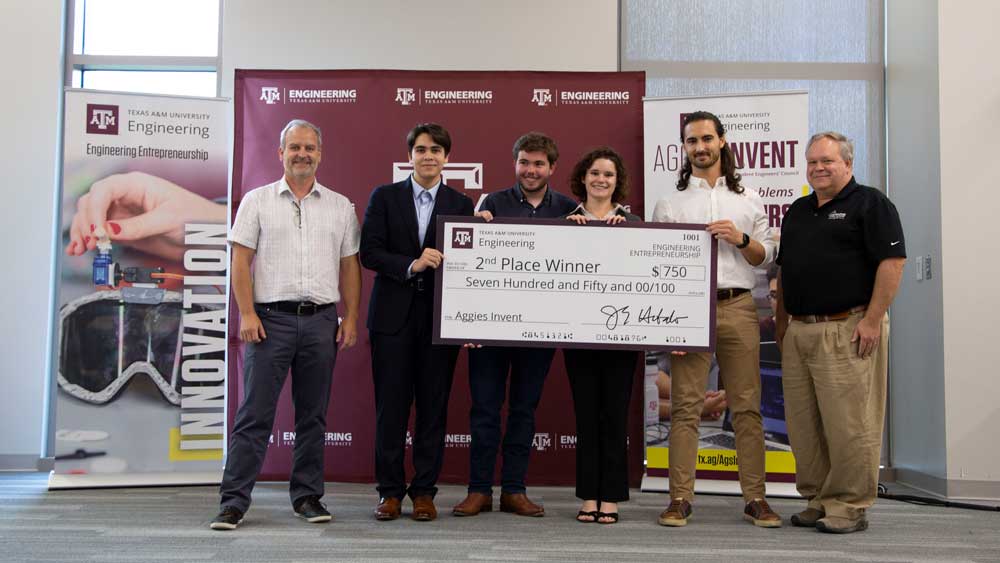 Second place team Ultrasonic poses with judges at Aggies Invent