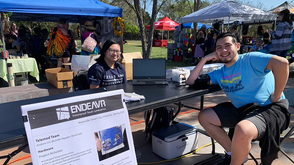 Michelle Nguyen and Andrew Lin are sitting at a booth prior to presenting their work at an event.