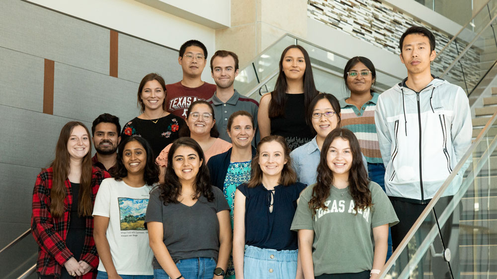 Dr. Alexandra “Alex” Walsh, center, second row, stands with her lab group. 