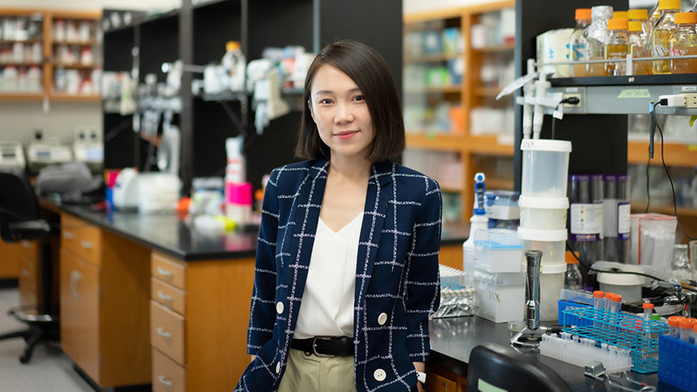 Dr. Chelsea Hu standing in her lab