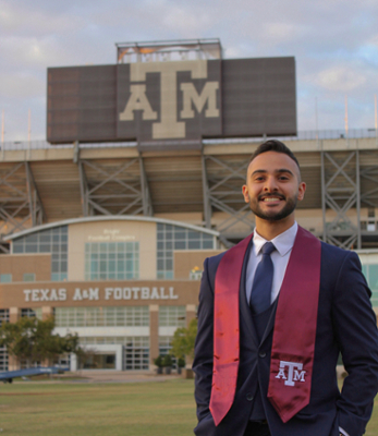 Hayder Alhilo stands in front of Kyle Field wearing his graduation stole.