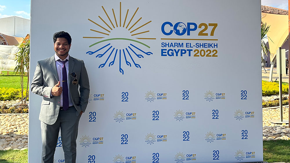 Niranjan Sitapure poses in front of a COP 27 walkway in Egypt at the UN Conference in Egypt.