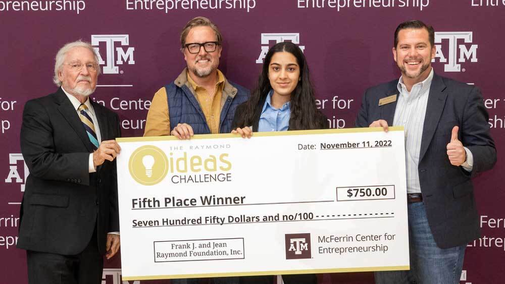 Suchitaa Sawhney holds her $750 check from the Raymond Ideas Challenge with judges.