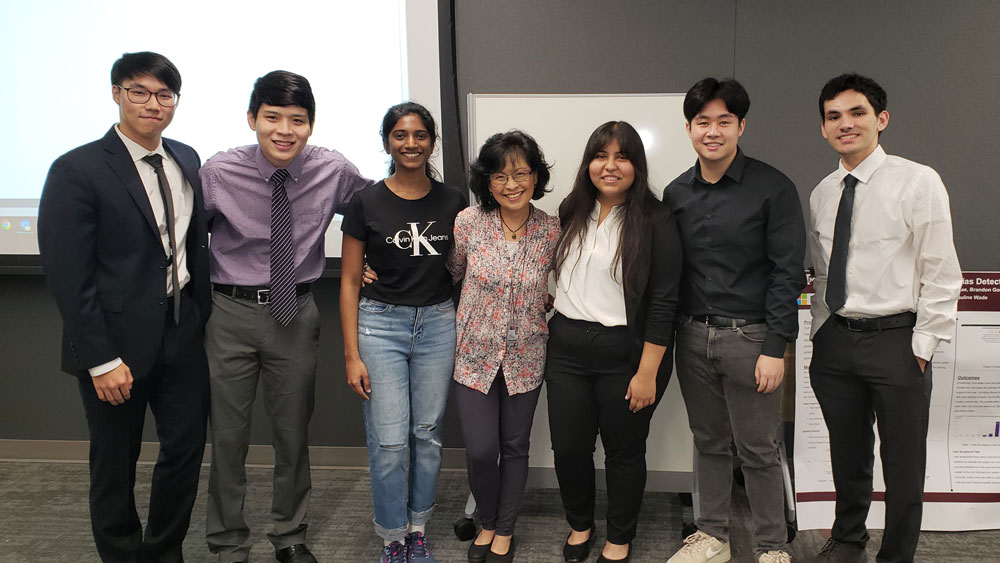 A team of Texas A&M University students next to their faculty mentor and teaching assistant after a presentation.