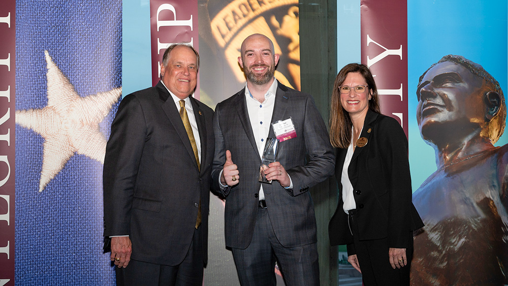 Matt Fransted holds his award and stands with Porter S. Garner III ‘79 (left) and Dara Hegar ‘95 (right).