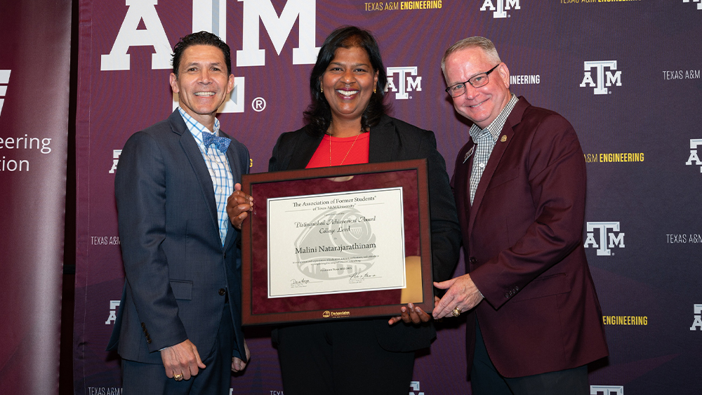 Dr. Malini Natarajarathinam holds her award while standing between Dr. John E. Hurtado ’95 and Dr. Marty Holmes '87.