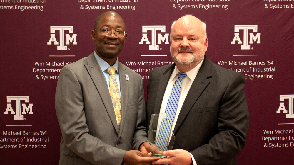 Department head Dr. Lewis Ntaimo, left, presents Rick Wilkinson with the Wm Michael Barnes '64 Department of Industrial and Systems Engineering’s 2023 Distinguished Former Student Award.