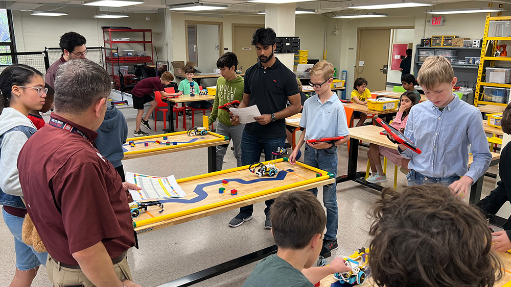MXET student observing the Oakwood Intermediate School students during the robotics competition.