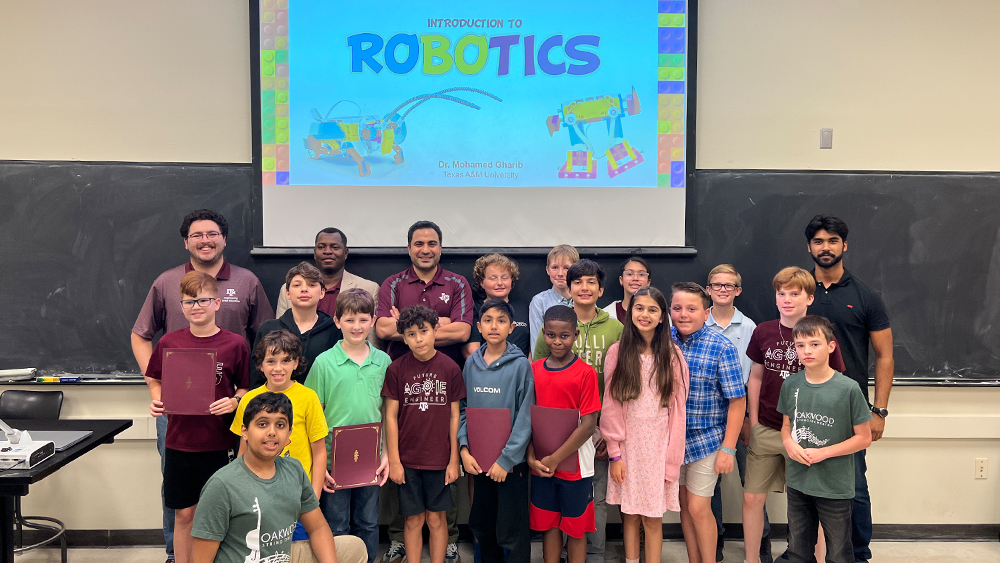 Dr. Mohamed Gharib stands with Multidisciplinary Engineering Technology STEM education students and Oakwood Intermediate School students in a group photo during the award ceremony.