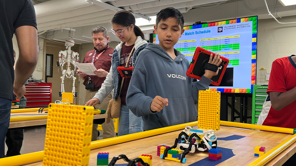 Oakwood students observing Lego robots during the MXET robotics competition.