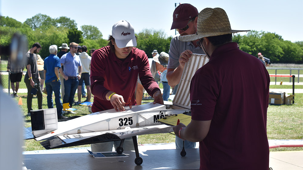 Two students loading payload into their Micro Class airplane.