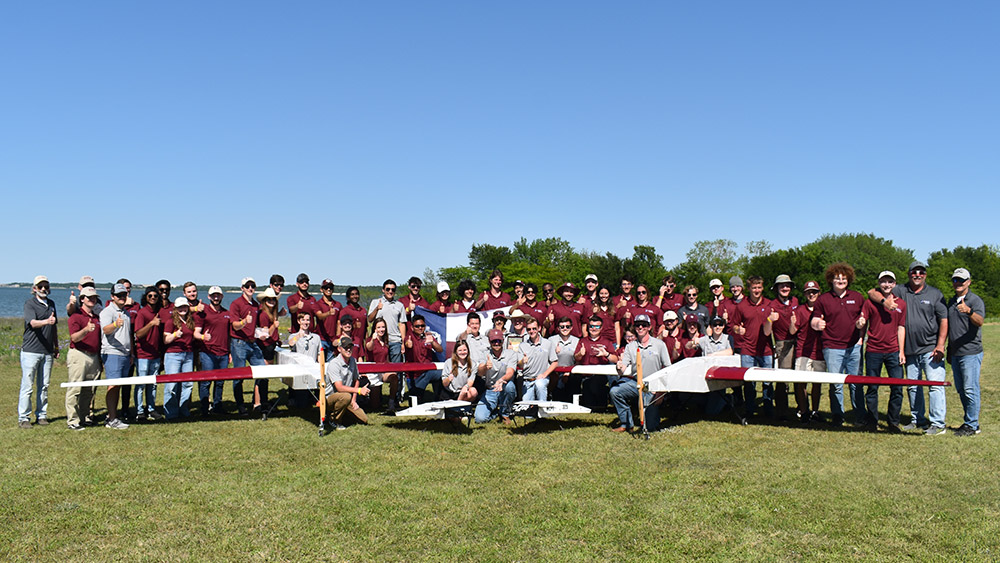 Group of students with their airplanes at the SAE Aero Design competition.
