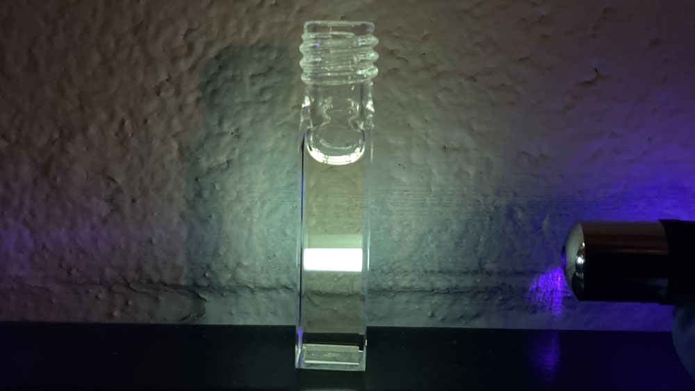 A test tube with water and a light shining on it