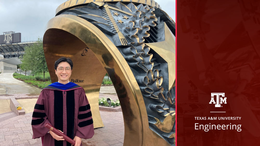 Dr. Taekwang Ha stands outside by the Aggie Ring statue on campus in his doctoral robes holding his degree. A stadium with the Texas A&amp;M logo is visible in the background.