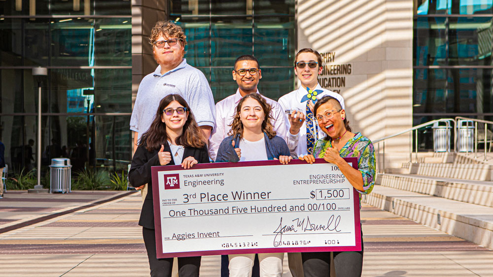 Aggies Invent Sandia's third-place winning team with their jumbo check for $1,500.