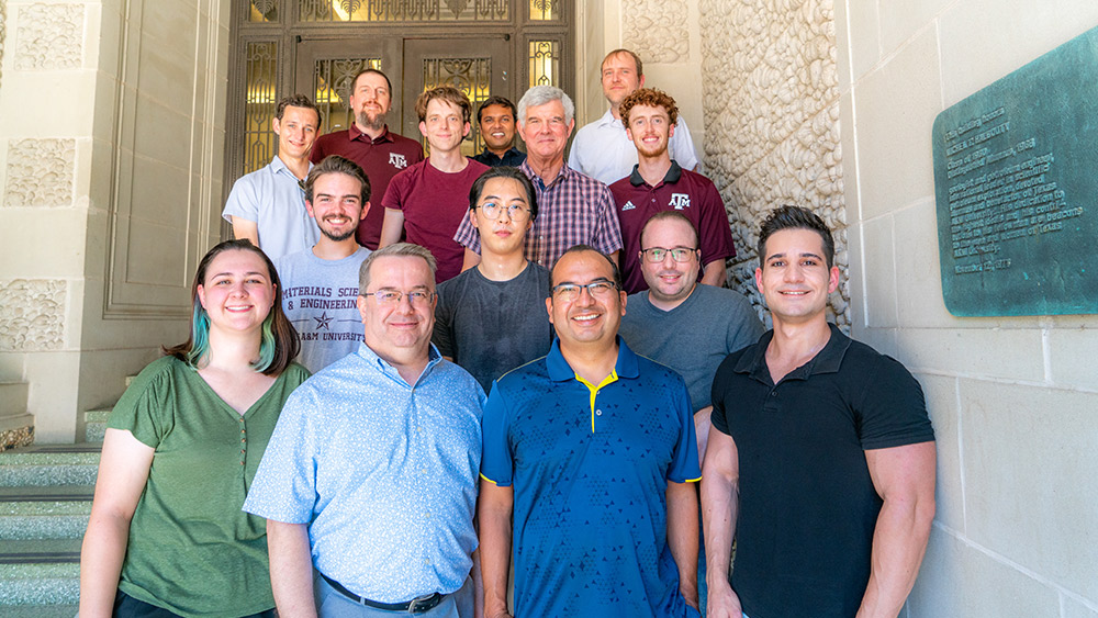 A group of materials science faculty standing on stairs
