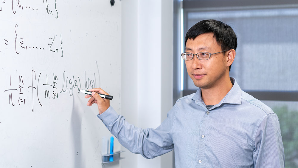 Dr. Yang standing next to white board
