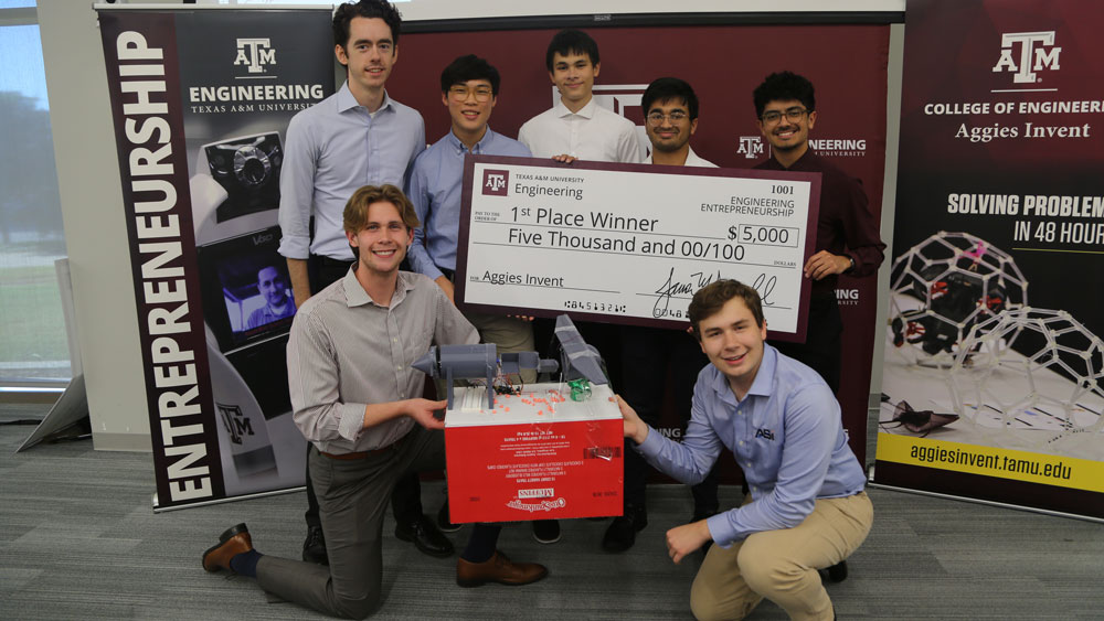 Seven students from Team BioTect holding an oversized check for $5,000.