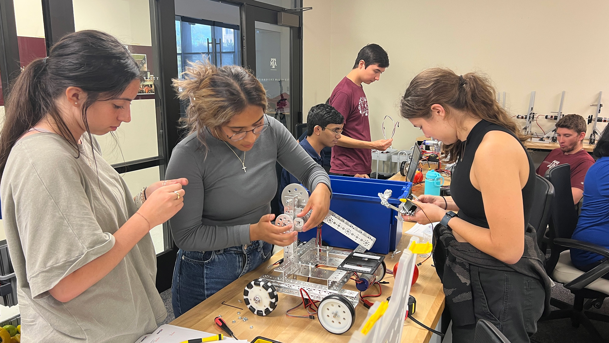 Seven students work on a robotics project.