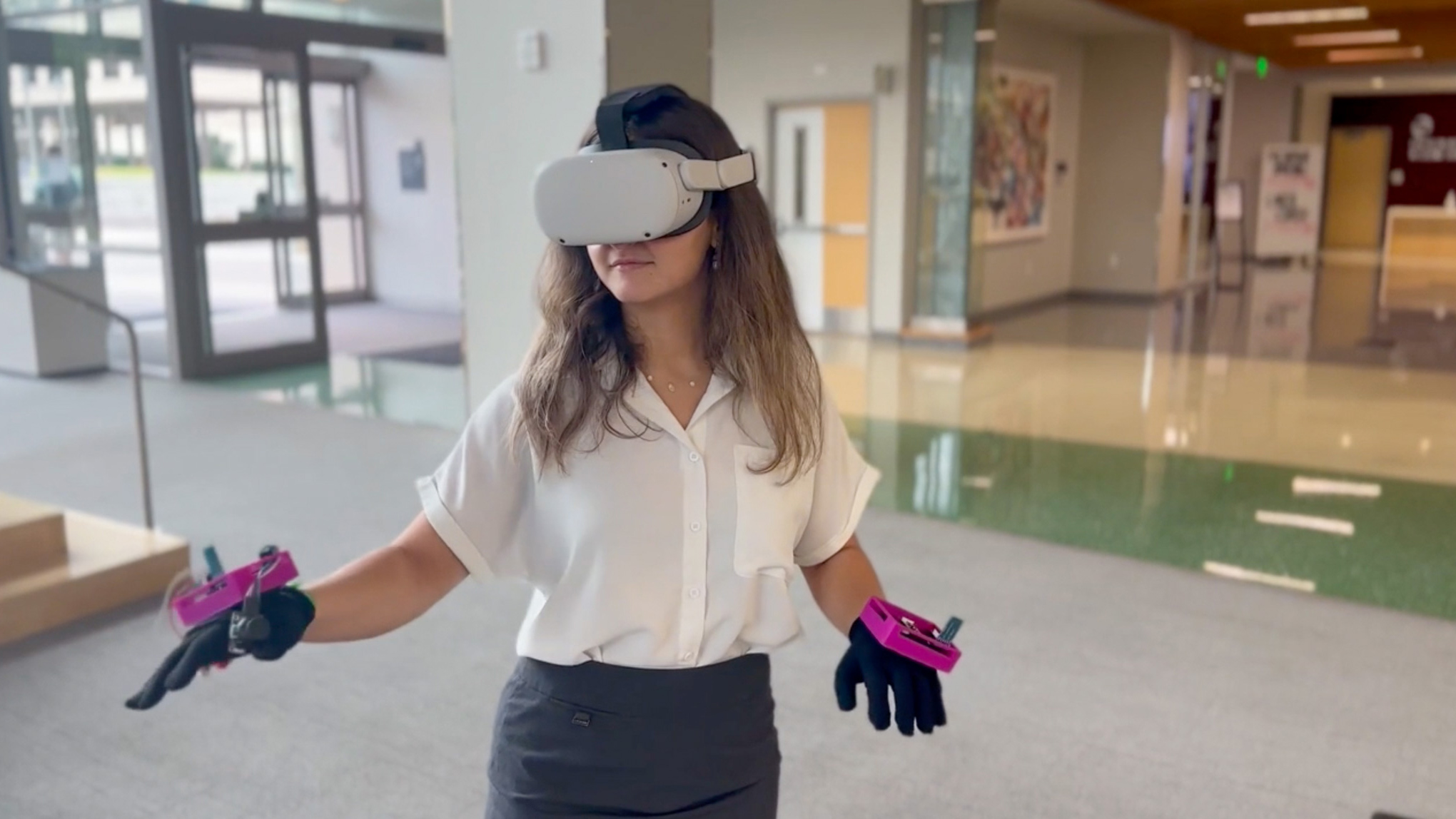 Deva Issa demonstrating the hand-tracking controllers that her team made.