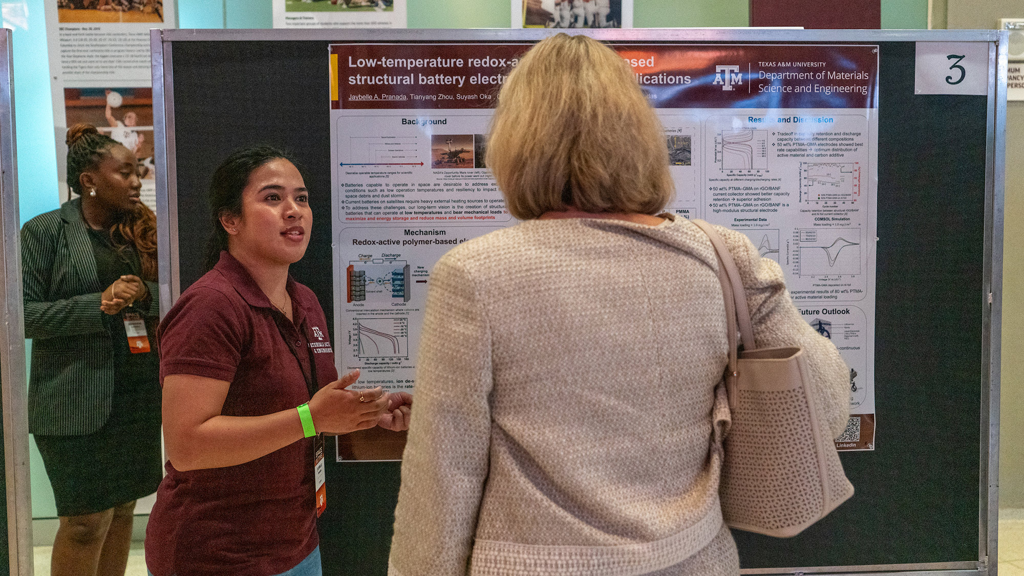 A female student explaining her research project to a faculty member.