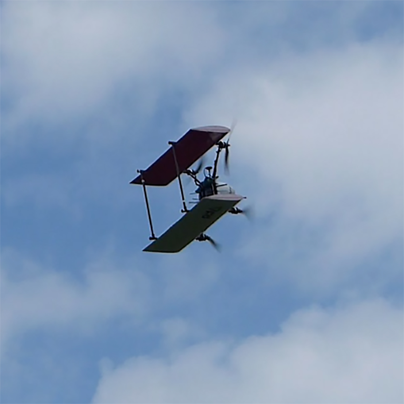 A quadcopter biplane in the sky.