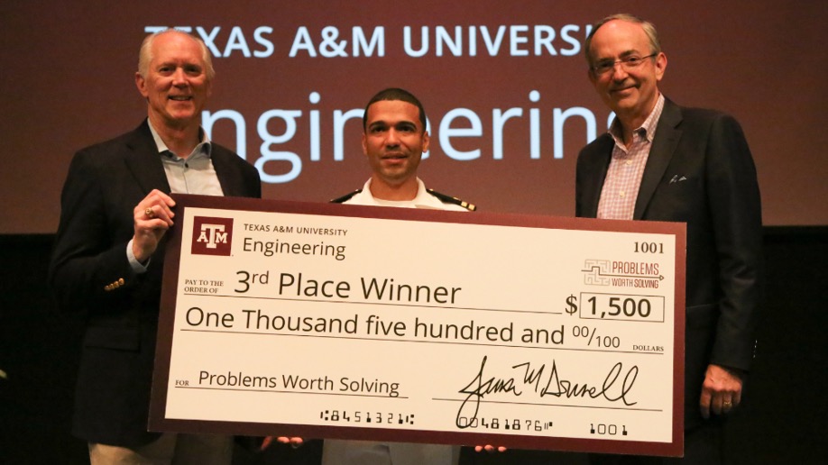 Three men hold a large check for $1,500. 