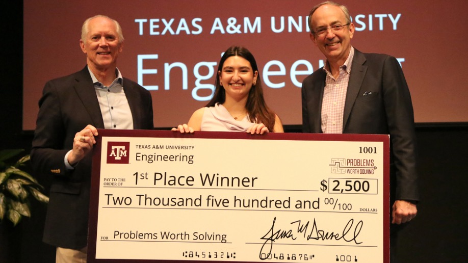 Two men and one woman hold a large check for $2,500.