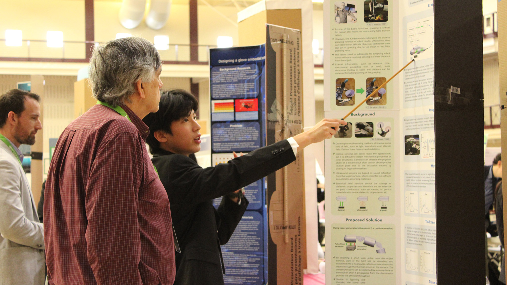 Two individuals engaged in a discussion in front of a research poster at an academic conference or event.