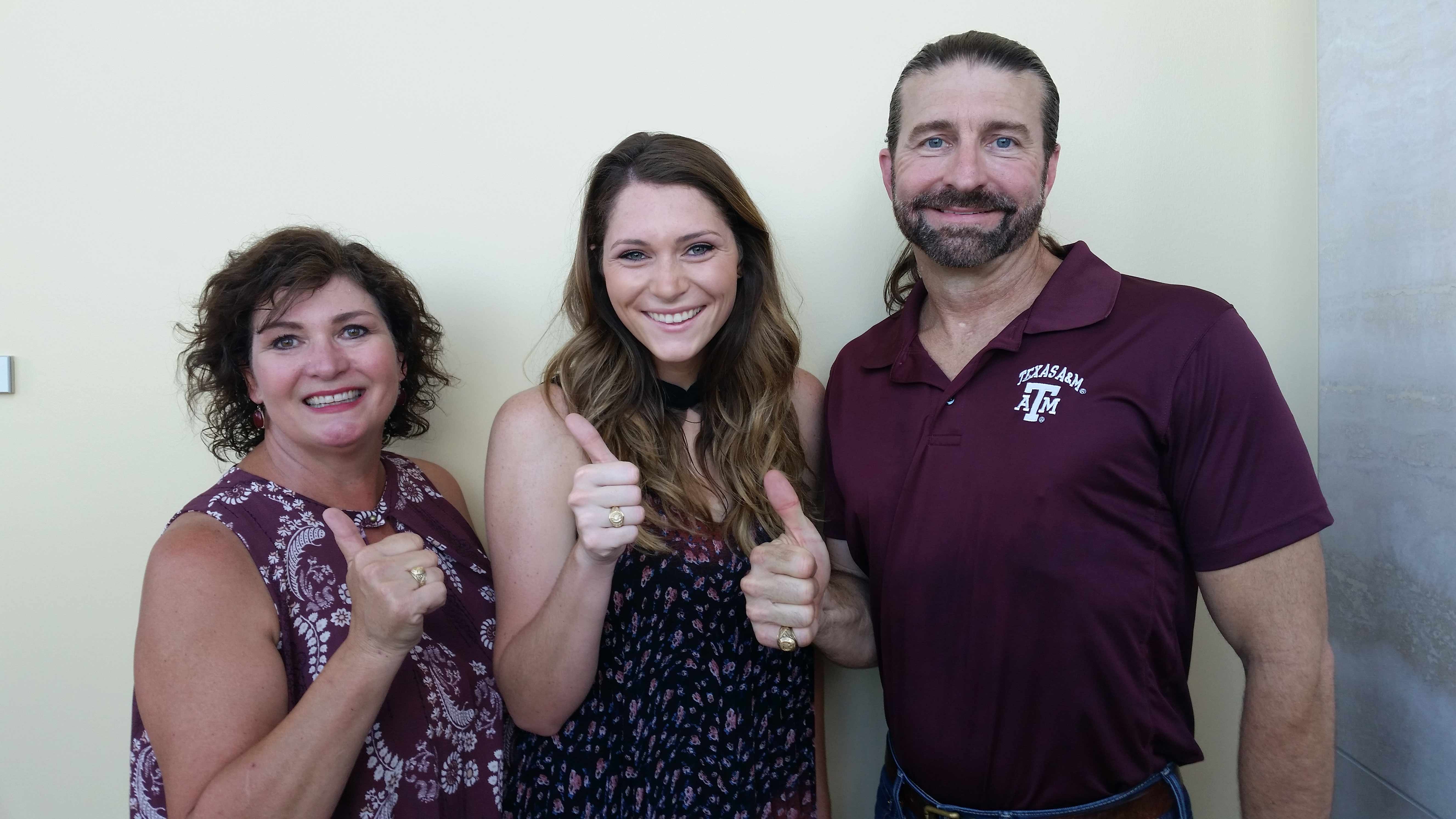 Man and two women pose with their rings.